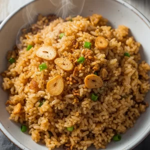 Create a vertical Pinterest pin image (1000x1500) for the recipe " Filipino Garlic Fried Rice Sinangag". 
Show a close-up of the prepared dish, vibrant and appetizing, with realistic textures and natural lighting. 
Add the recipe title "  Filipino Garlic Fried Rice Sinangag      " in elegant, clean, and large typography at the top or center. 
Use a readable, modern font, and make sure the text stands out clearly. 
Do NOT include any logo or website name. Keep the design simple, professional, and eye-catching.
