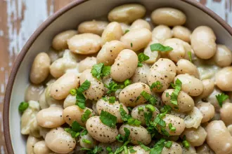 Create a vertical Pinterest pin image (1000x1500) for the recipe “ Creamy Southern Butter Beans " Show a close-up of the prepared dish, vibrant and appetizing, with realistic textures and natural lighting. Add the recipe title " Creamy Southern Butter Beans " in elegant, clean, and large typography at the top or center. Use a readable, modern font, and make sure the text stands out clearly. Do NOT include any logo or website name. Keep the design simple, professional, and eye-catching.